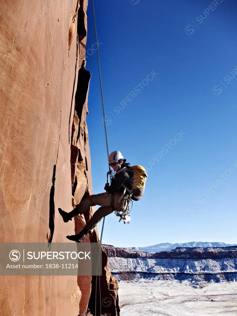 Rock Climber Rappeling Steep Cliff, Indian Creek, Canyonlands National Park, Utah, USA