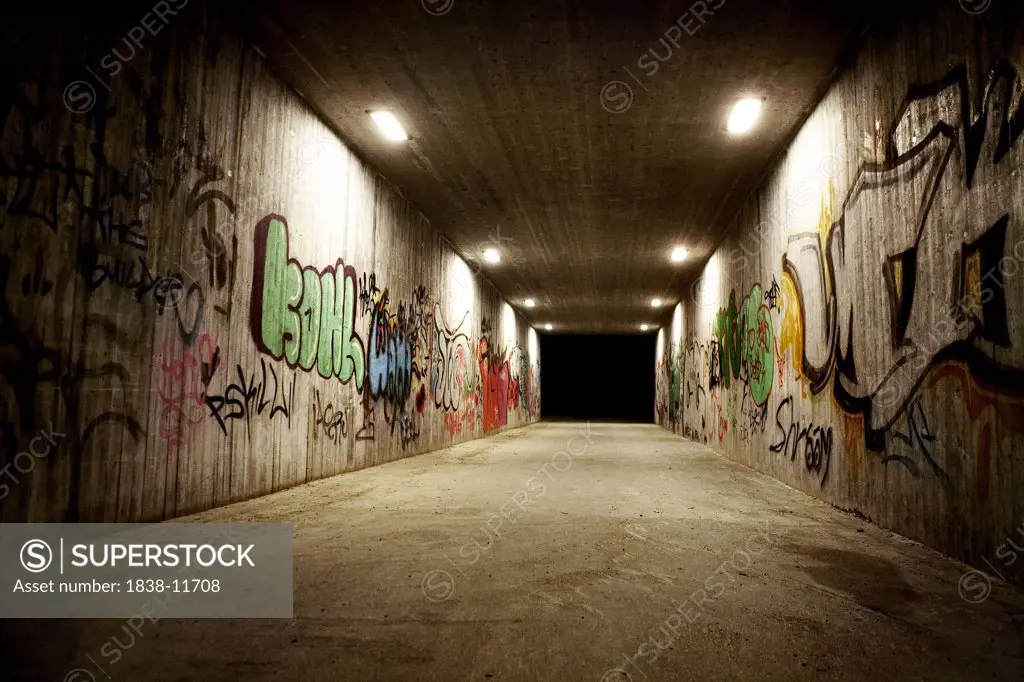 Illuminated Tunnel With Graffiti on Walls