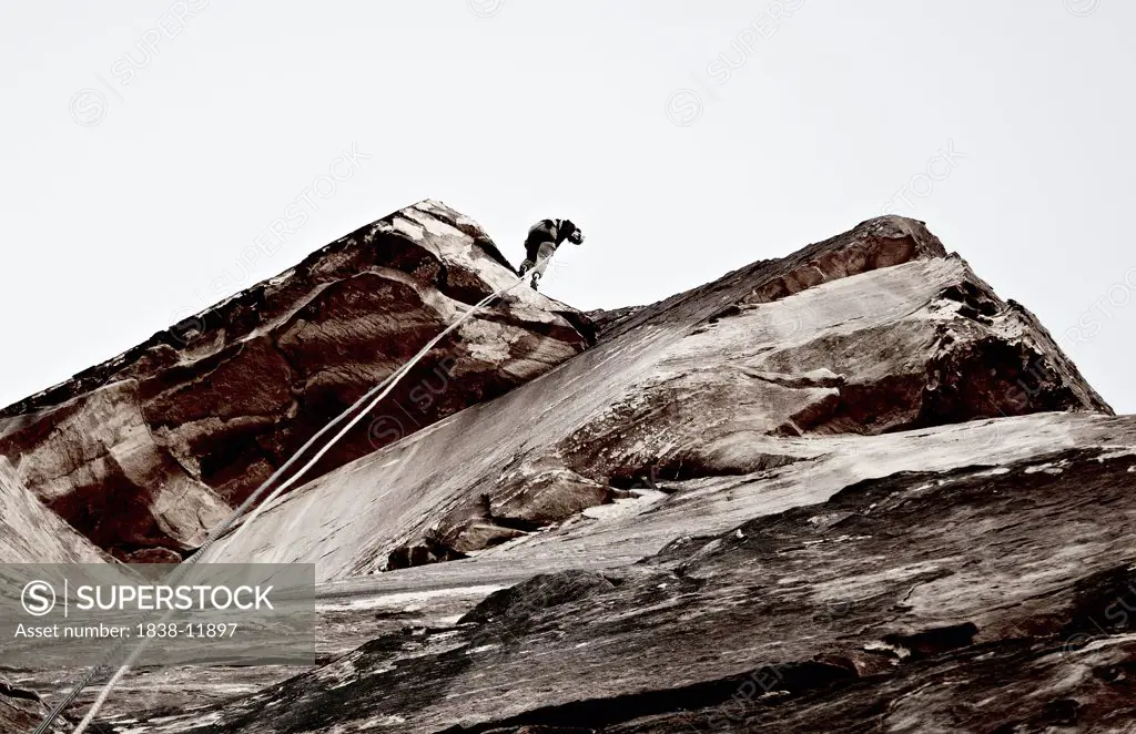 Rock Climber Descending Cliff