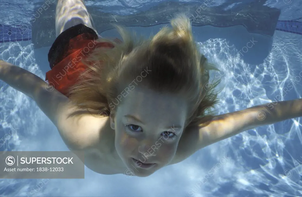 Young Blonde Boy Swimming Underwater