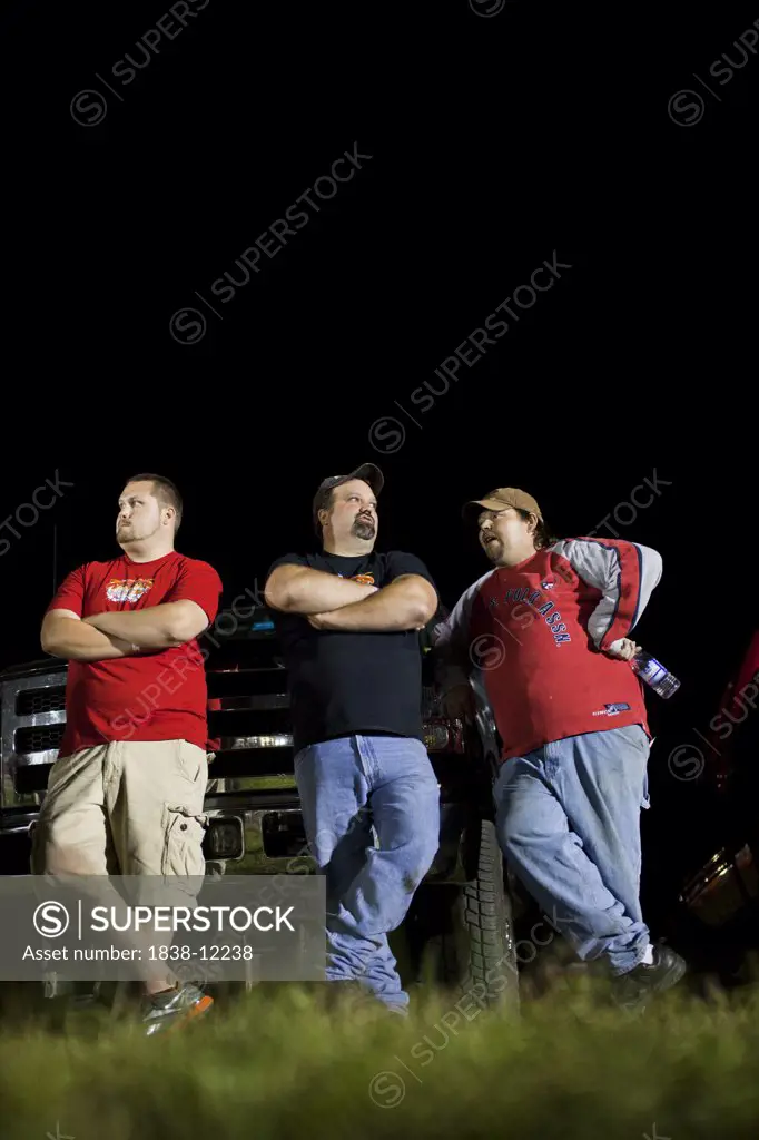 Three Overweight Men Leaning Against Truck