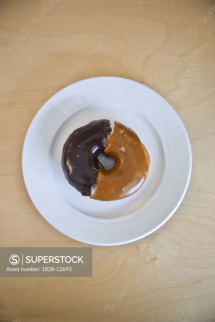 Chocolate and Maple Frosted Doughnut Halves Together on Plate