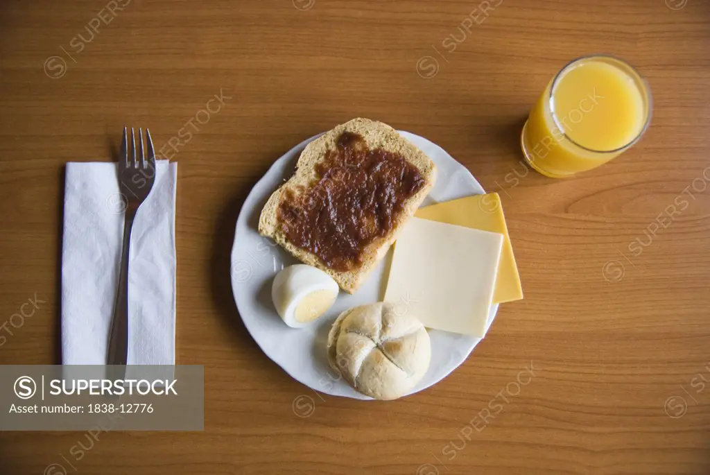 Toast with Jam, Hardboiled Egg, Roll, Cheese and Orange Juice for Breakfast