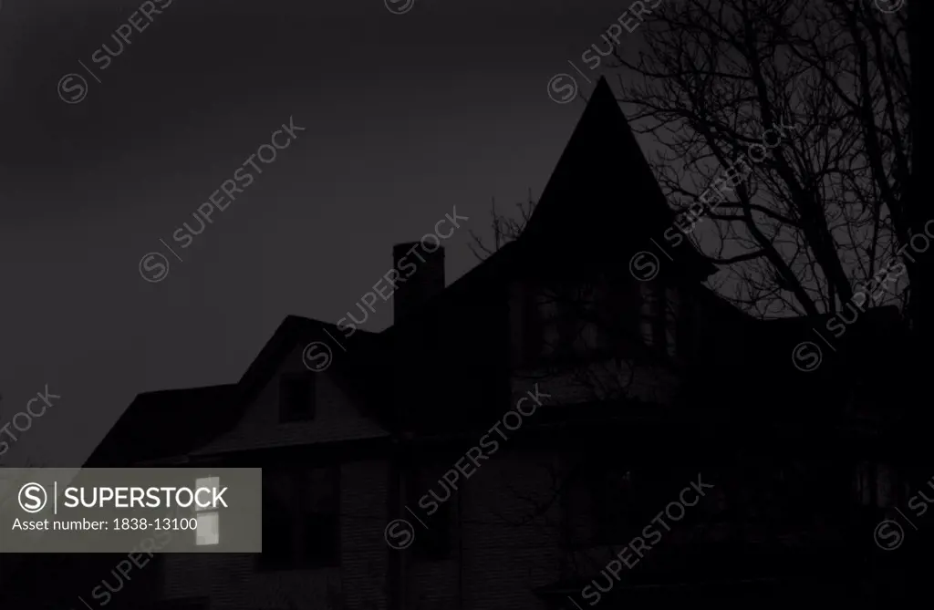 Old House at Night With One Window Illuminated