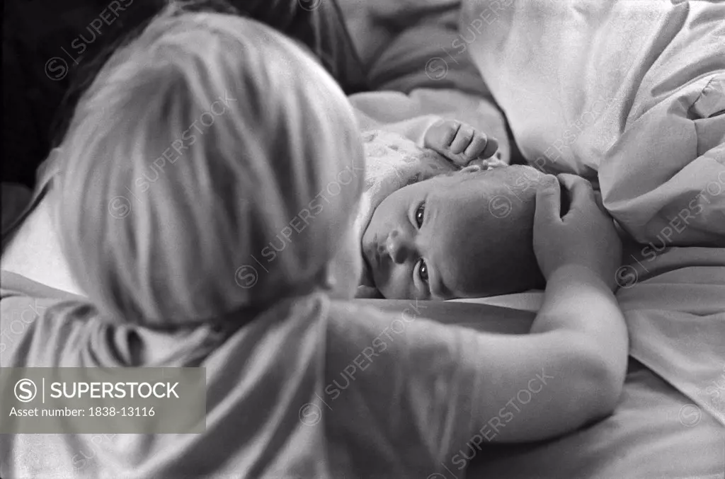 Young Boy Looks at Newborn Baby