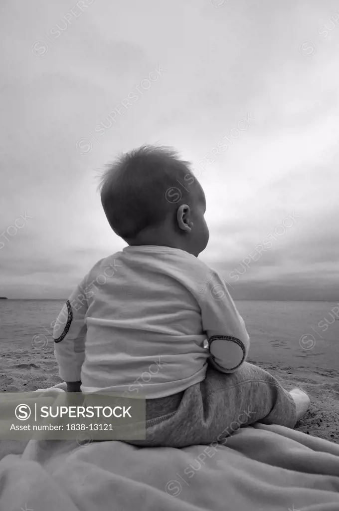 Baby Boy Sitting on Beach, Rear View