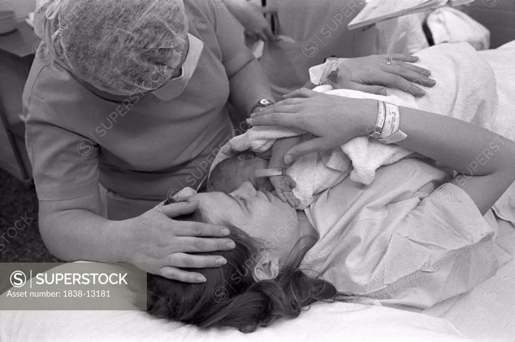 Hospital Nurse Attending Mother With Newborn Baby