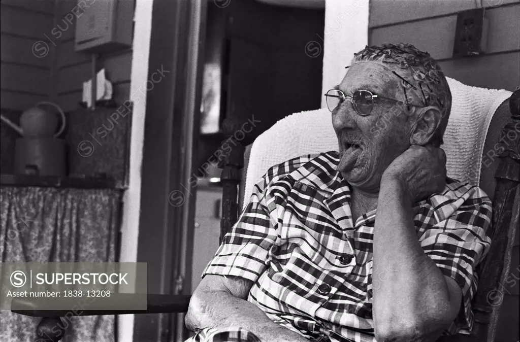 Elderly Woman Sitting on Porch and Sticking Tongue Out