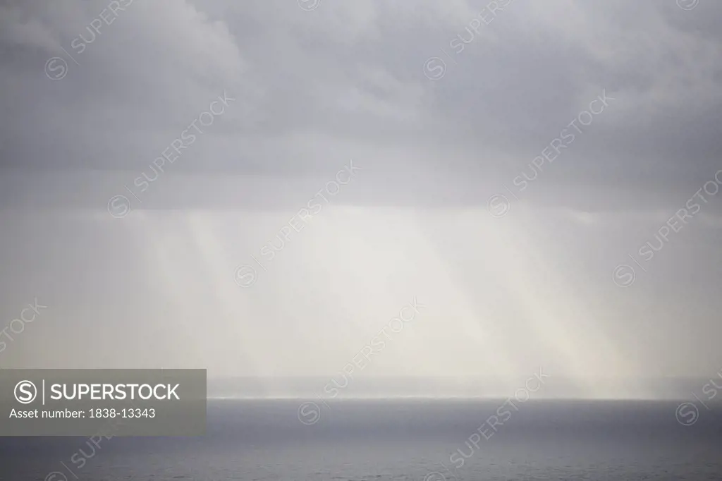Sun Rays Reflected on Ocean Through Gray Clouds