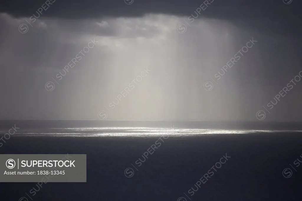 Sun Rays Reflected on Ocean Through Gray Clouds