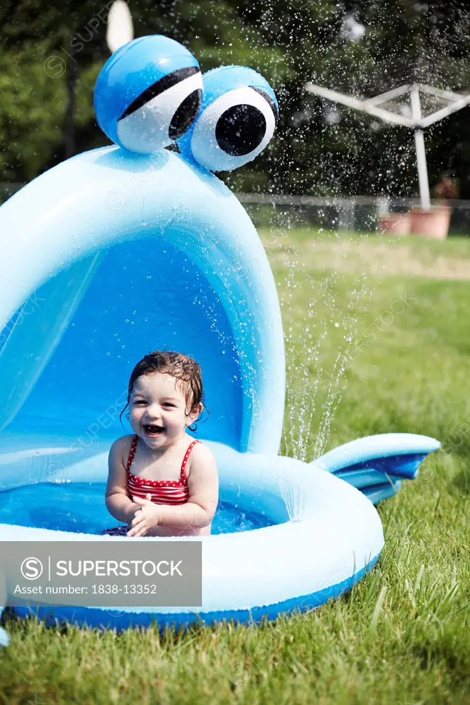 Young Girl in Red Bathing Suit Sitting in Small Pool