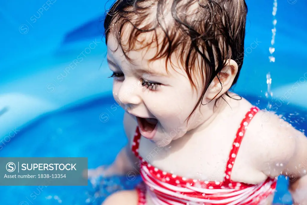 Young Girl in Red Bathing Suit Sitting in Small Pool, Close-Up