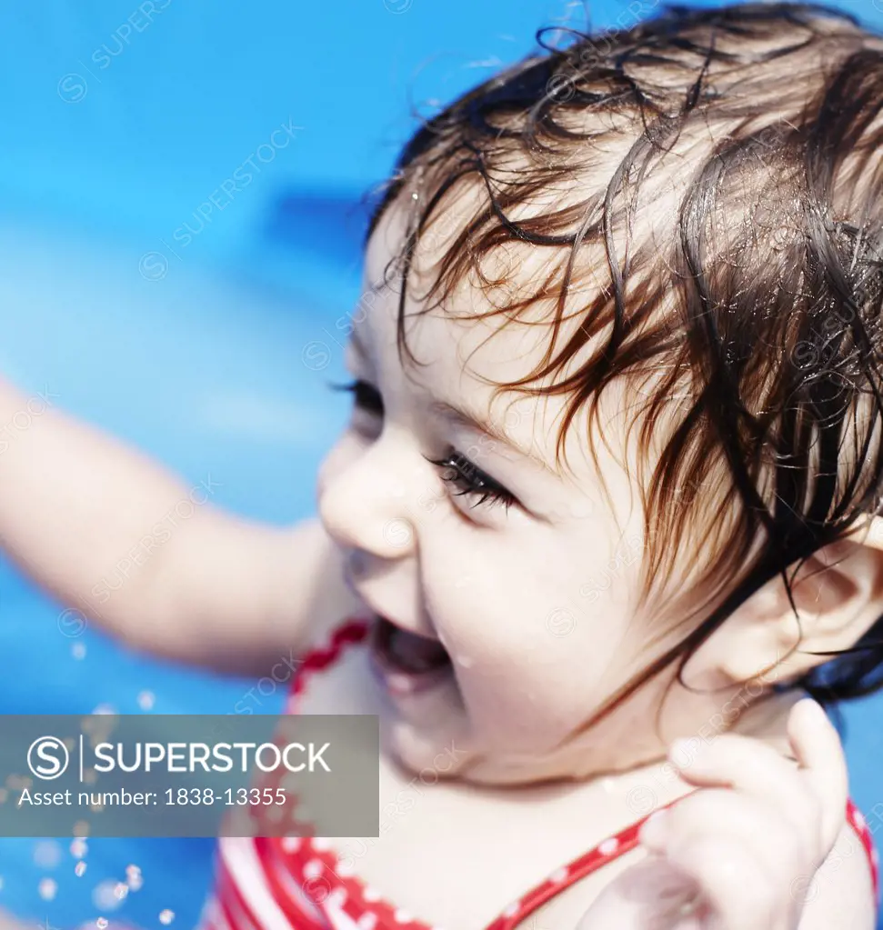 Young Girl in Red Bathing Suit Sitting in Small Pool, Close-Up