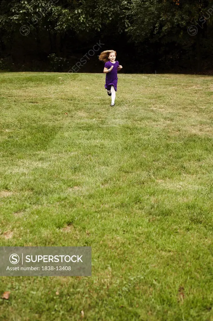 Young Girl in Purple Dress Running in Field