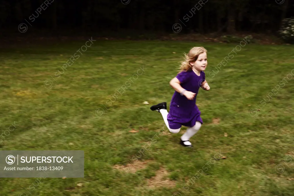 Young Girl in Purple Dress Running in Yard