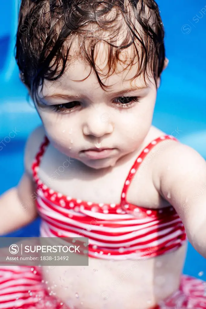 Young Girl in Red Bathing Suit Sitting in Small Pool, Close Up