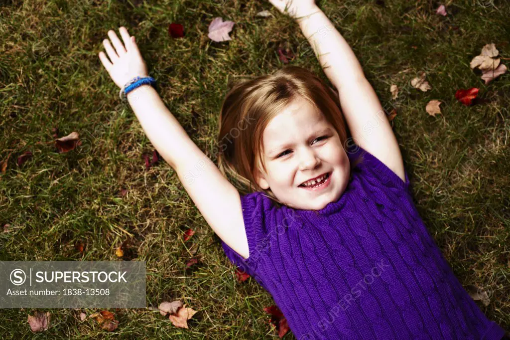 Young Smiling Girl Laying on Ground