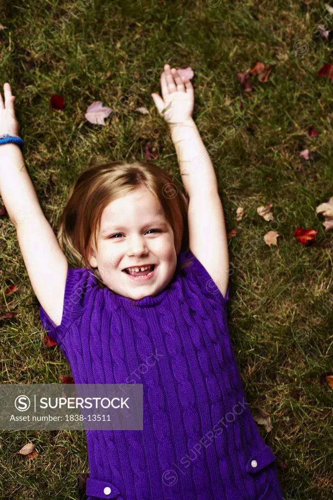 Young Smiling Girl Laying on Ground