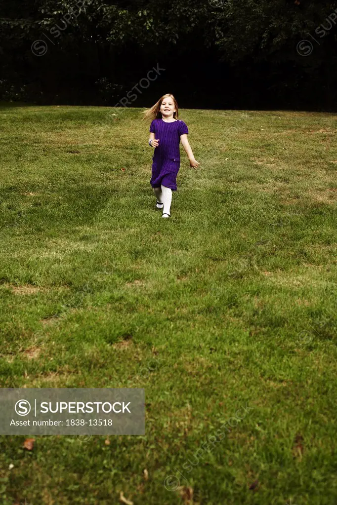 Young Girl in Purple Dress Running in Yard