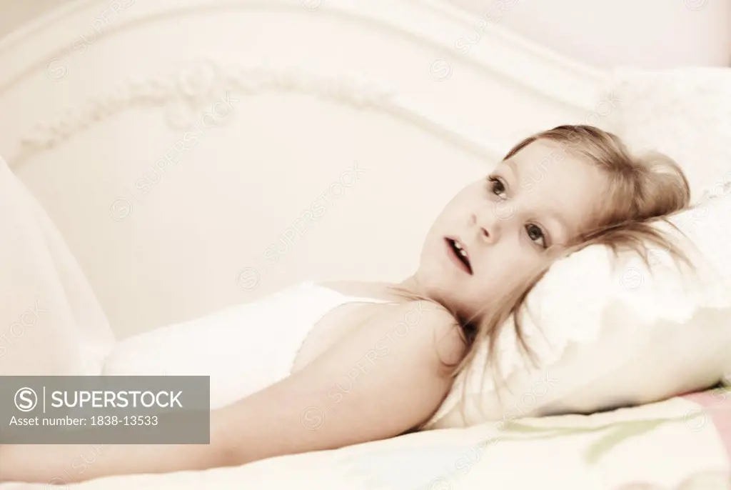 Young Girl Laying on Bed