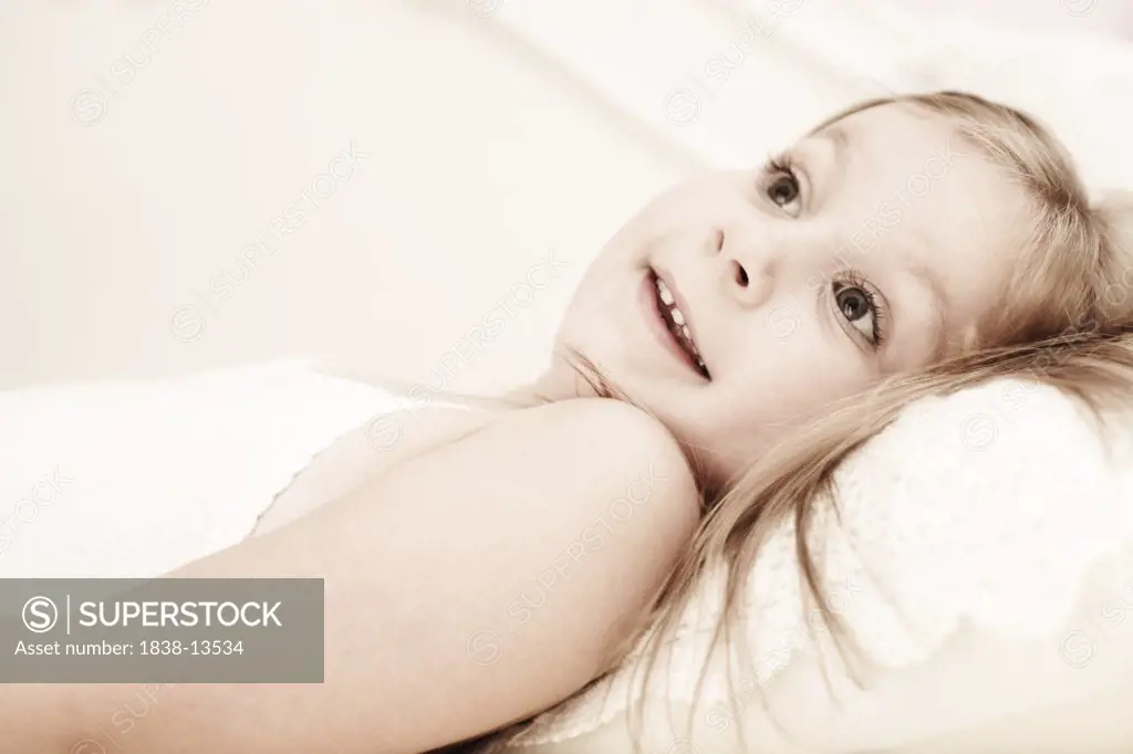 Young Smiling Girl Laying on Bed