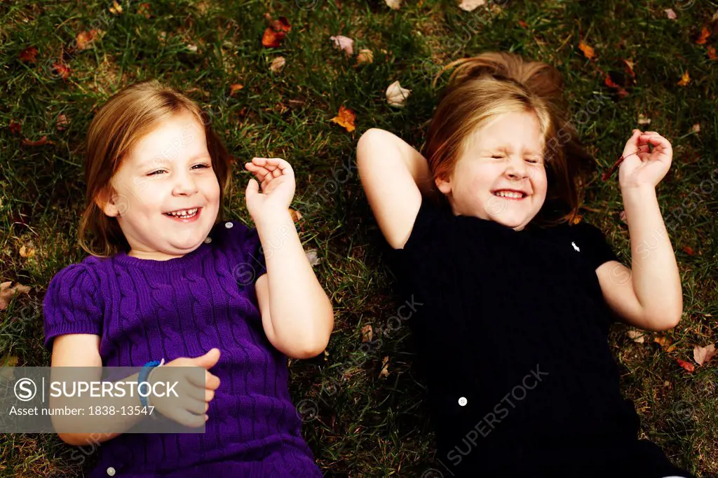Two Young Girls Laying on Grass