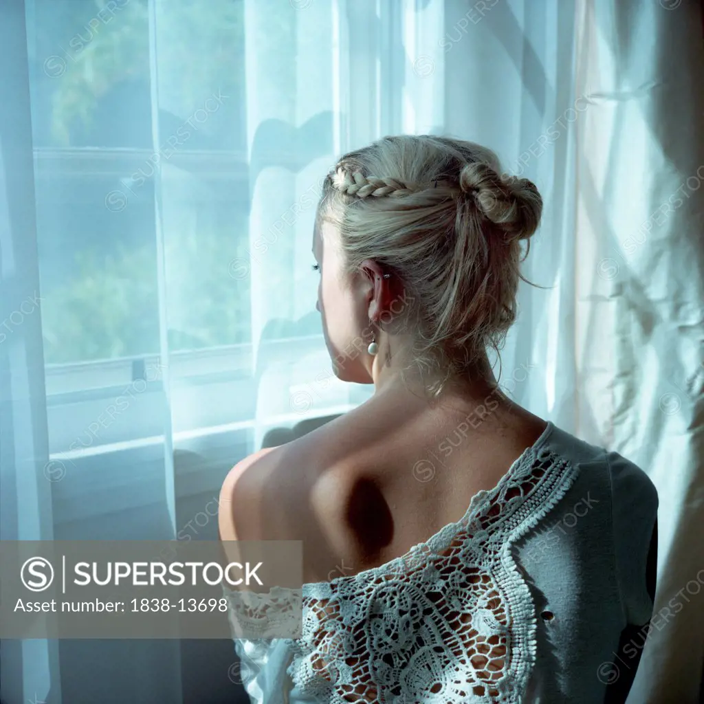 Young Blonde Woman at Window, Rear View