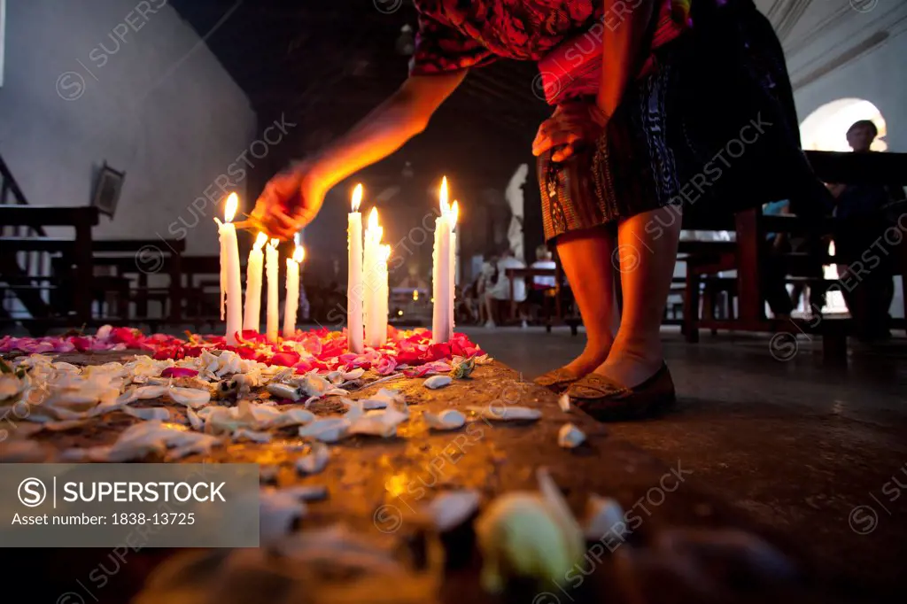 Woman Lighting Candles in Church