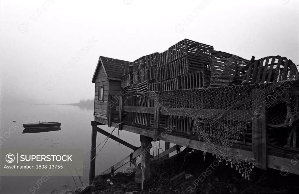 Pile of Lobster Crates Behind Shack on Dock, Maine, USA