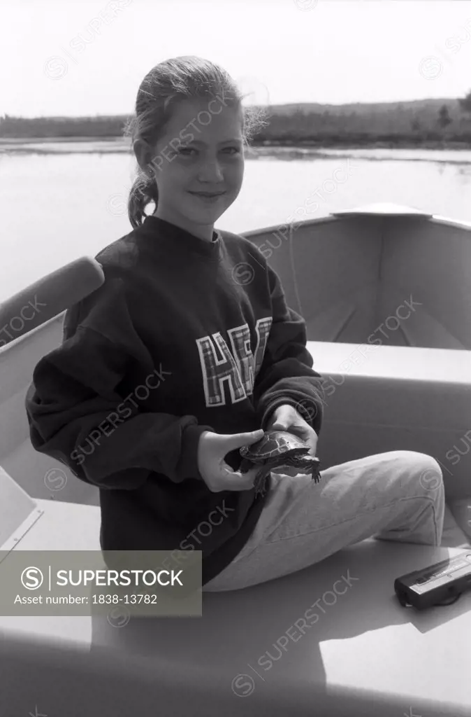 Girl Holding Turtle on Rowboat