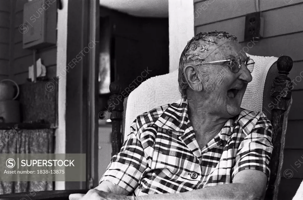 Elderly Woman Sitting on Porch Laughing