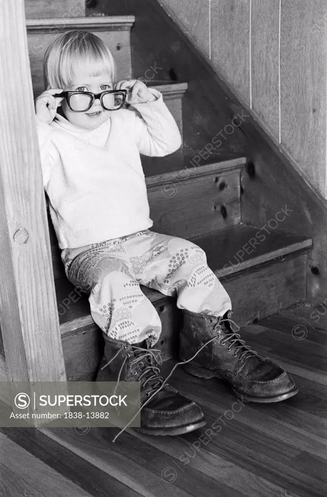 Young Boy Wearing Adult Eyeglasses and Boots