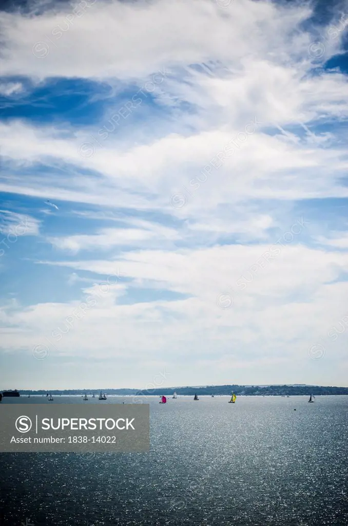 Sail Boats in Distant Water Under Blue Sky