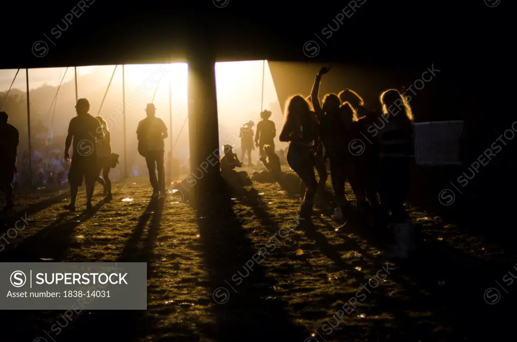 Silhouetted Summer Music Festival Goers Under Dark Tent at Sunset, Isle of Wight, UK