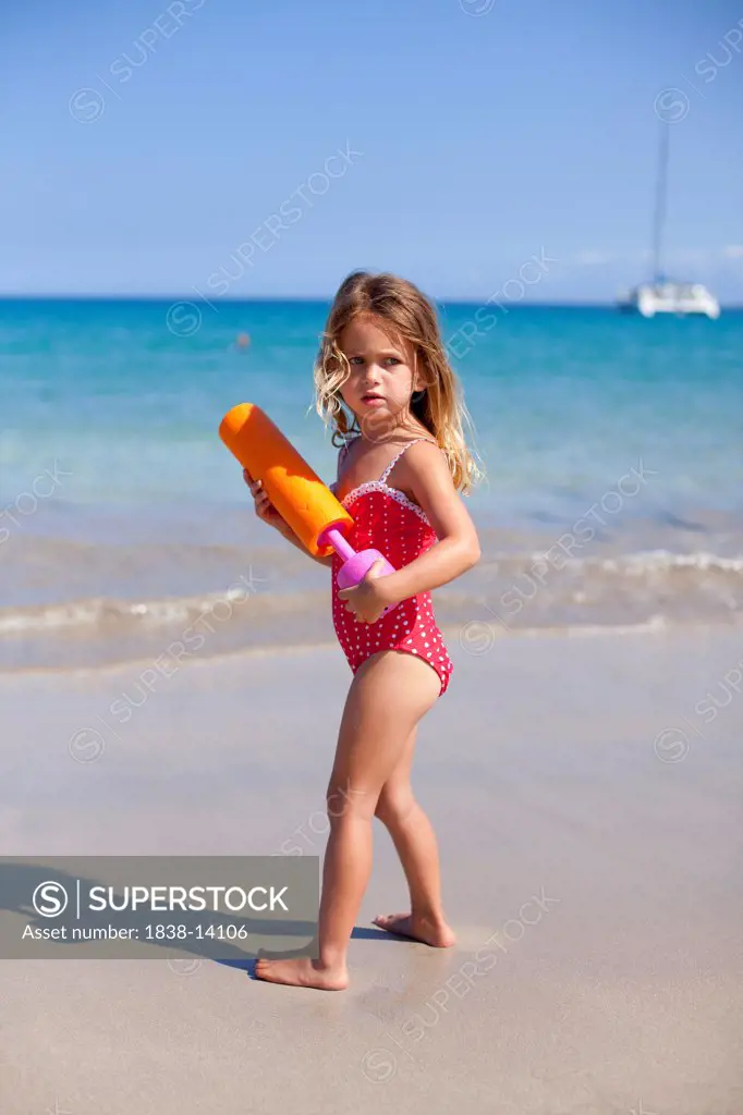 Young Girl on Beach With Squirt Gun