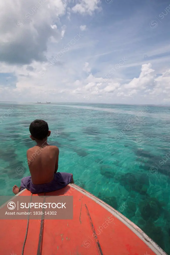 Young Boy Sitting at Front of Boat and Looking out to Sea, Borneo