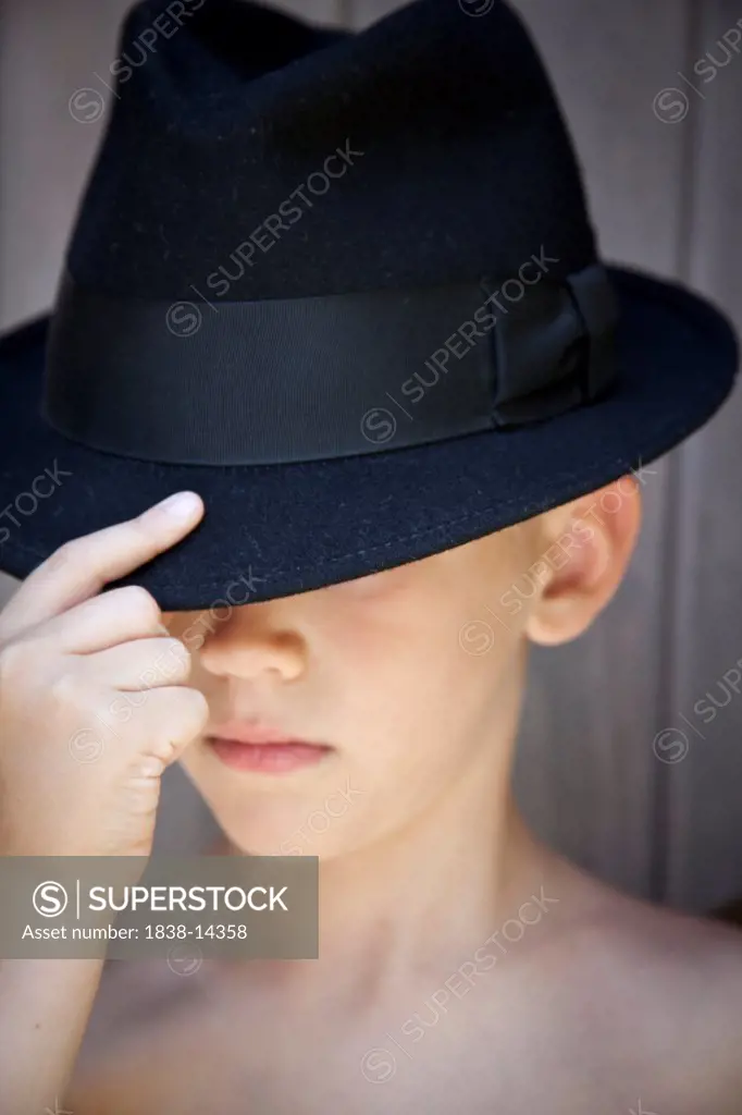 Young Boy Touching Brim of Fedora Hat