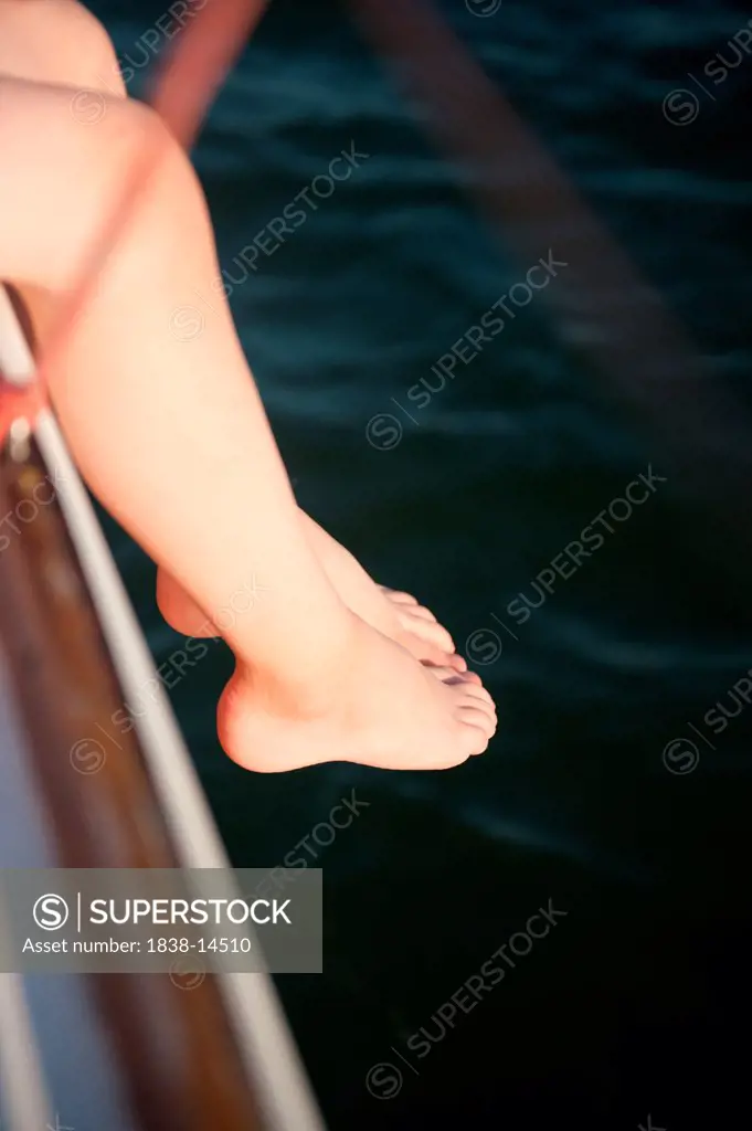 Girl Dangling Feet off Side of Sailboat