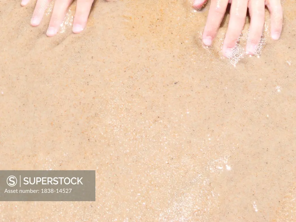 Hands in Wet Sand at Beach
