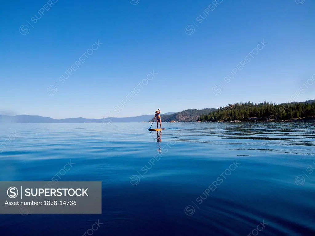 Woman Paddling on Lake in Distance