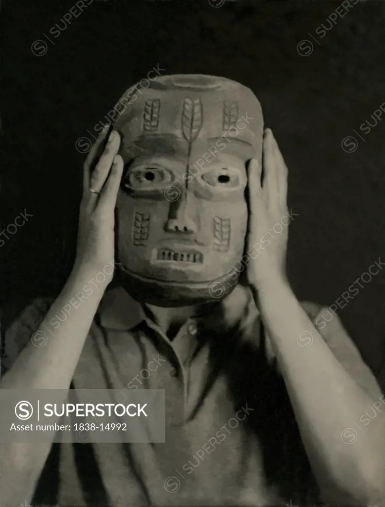 Man Holding Mask in front of Face