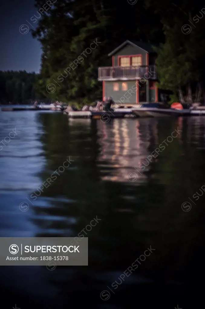 Blurred Cottage Reflecting in Lake at Dusk