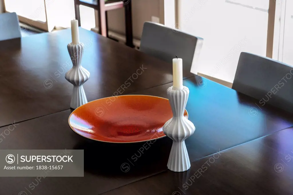 Large Orange Bowl with Candles on Dining Room Table with Modern Aluminum Chairs