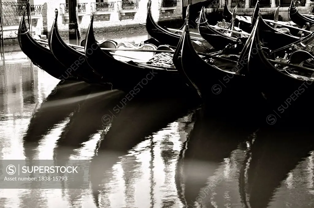 Row of Gondolas Reflected in Canal Water, Venice, Italy