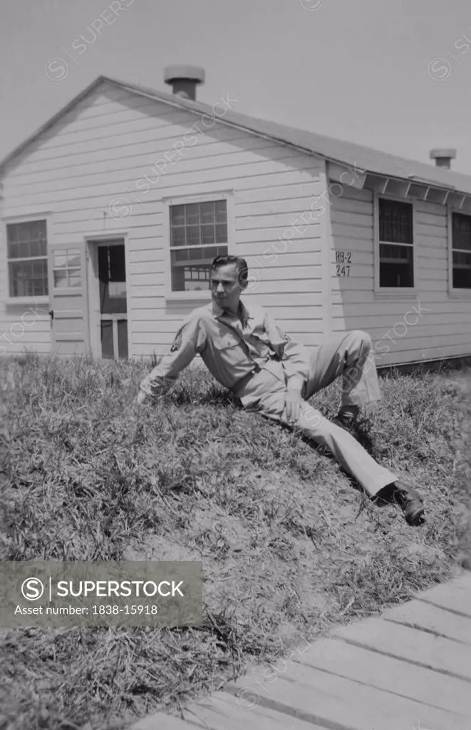 Soldier Relaxing on Ground Near Military Building, WWII, 325th Infantry, US Army Military Base , Camp Claiborne, Louisiana, USA, 1942