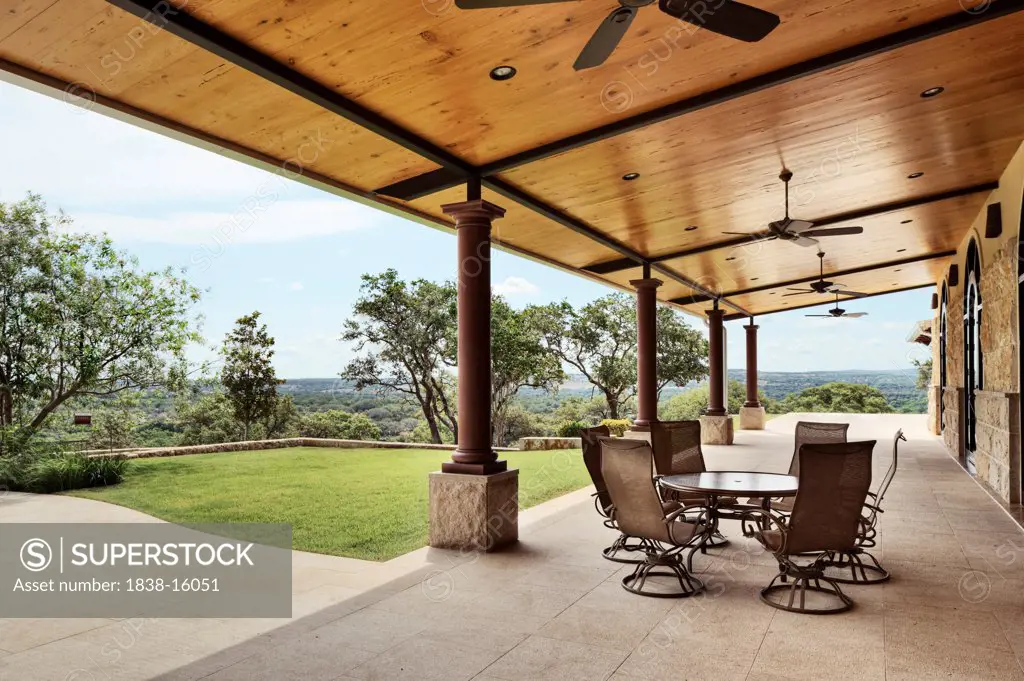 Long Covered Portico with Wood Ceiling and Celling Fans and View of Countryside