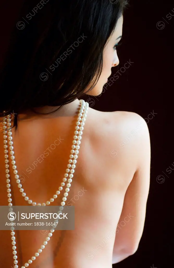 Sensuous Nude Woman with Long Strand of Pearls Hanging Down Back, Rear View