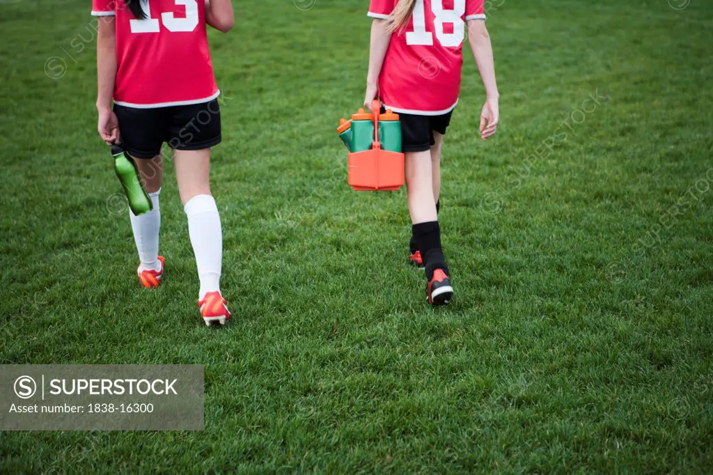 Two Young Female Soccer Players Walking off Field, Rear View