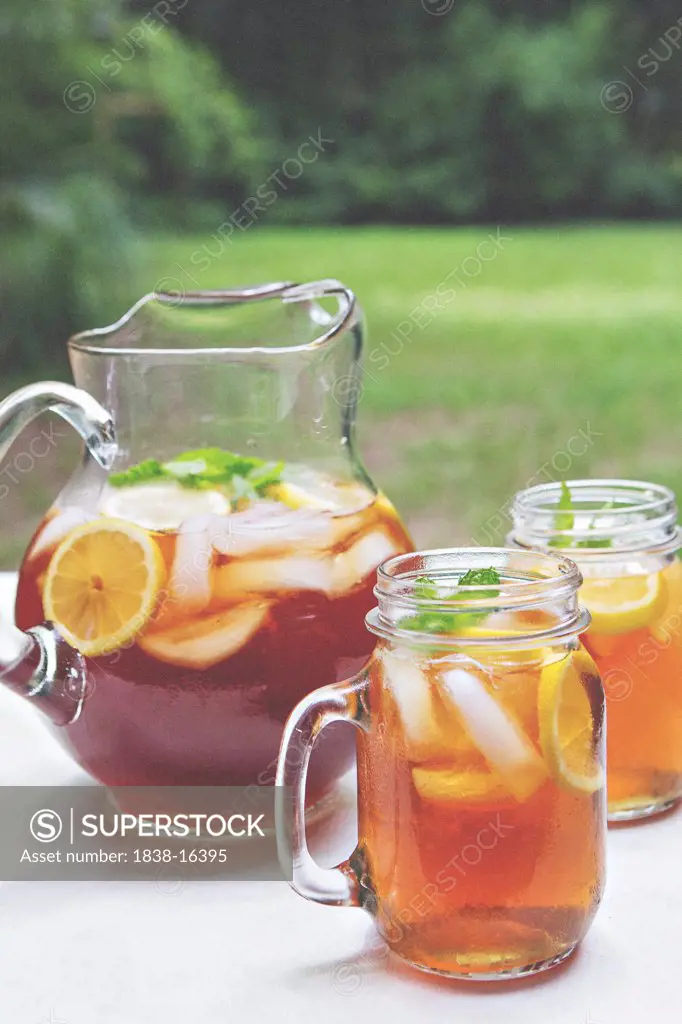 Iced Tea in Pitcher and Glass Mugs with Lemon and Mint