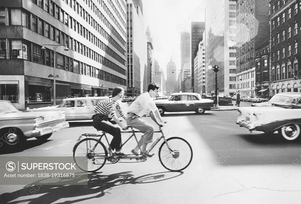 Couple riding Tandem Bicycle, Park Avenue and 57th Street, New York City, New York, USA, Angelo Rizzuto, Anthony Angel Collection, May 1959